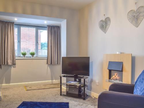 a living room with a tv and a fireplace at Corner Spot in Hednesford