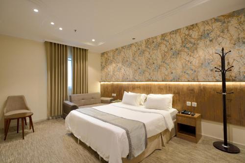 a hotel room with a bed and a chair at فندق الخلفاء الماسى الفندقيه in Mecca