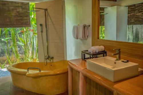 a bathroom with a large tub and a sink at Villa Seminyak Estate & Spa - By Astadala in Seminyak
