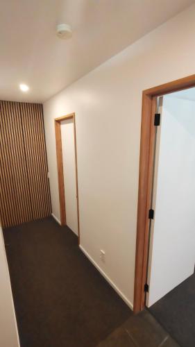 an empty room with a door and a hallway at Kōwhai Corner Room at Goldfield Heights in Queenstown