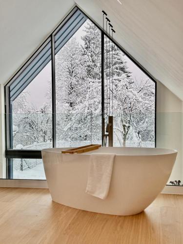 a bath tub in a bathroom with a large window at Casa Verta in Skrad