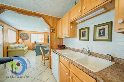 a kitchen with a sink and a living room at Cg Beach Bungalow #1 in Myrtle Beach
