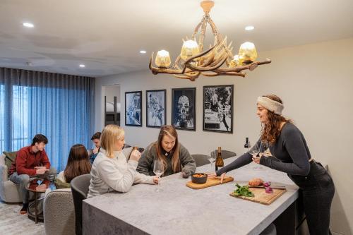 a group of people sitting around a table with wine glasses at Chalet Apartments - Mt Buller Apartment Rentals in Mount Buller