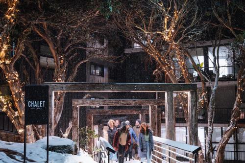 a group of people walking through a gate in the snow at Chalet Apartments - Mt Buller Apartment Rentals in Mount Buller