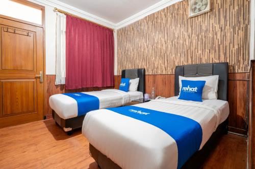 a hotel room with two beds in it at Rehat at Hotel Sabang in Bandung