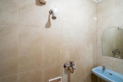 a bathroom with a shower with a sink and a mirror at Rehat at Hotel Sabang in Bandung