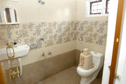 a bathroom with a toilet and a sink at Blooms home stay in Thekkady