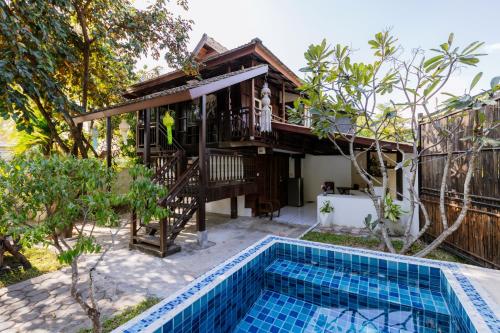 a villa with a swimming pool and a house at Teewana Resort Chiang Mai in Chiang Mai