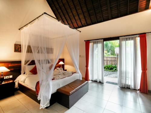 a bedroom with a bed with a canopy at Pondok Massas Ubud in Ubud