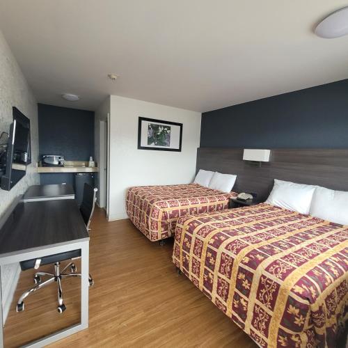 a hotel room with two beds and a sink at Budget Inn in Durham