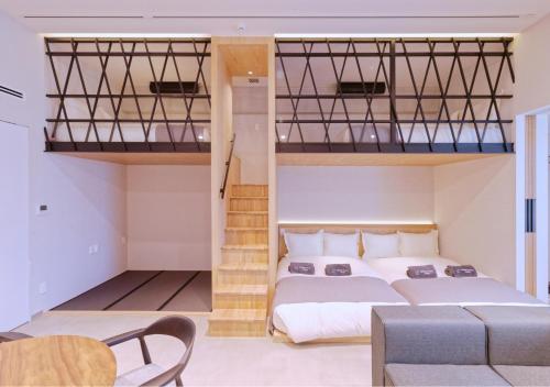 a bedroom with a bed and two bunk beds at Sakura Cross Inn & Sauna Ishigaki in Ishigaki Island