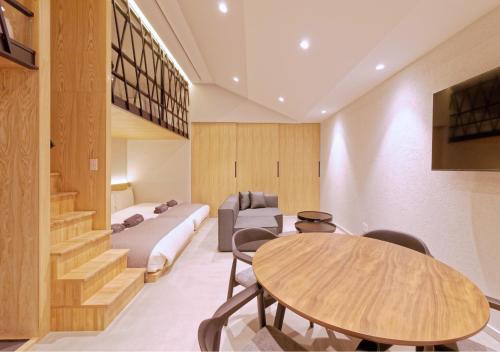 a room with a bed and a table and chairs at Sakura Cross Inn & Sauna Ishigaki in Ishigaki Island