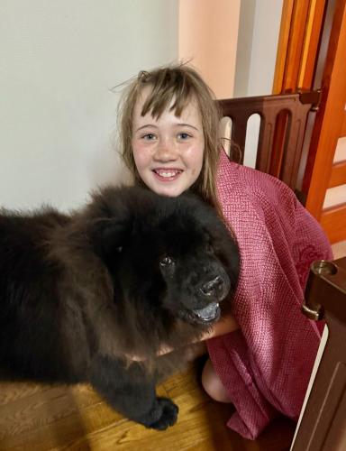 a little girl sitting on a chair with a black dog at live takayama-Stay with a Rescue Dog and Local Host in Takayama
