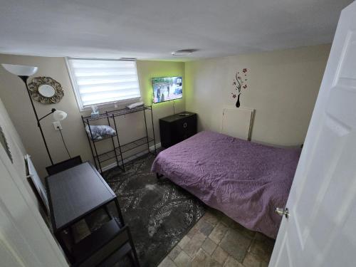 a bedroom with a purple bed and a window at Bright Room in Walkout Basement in Pickering