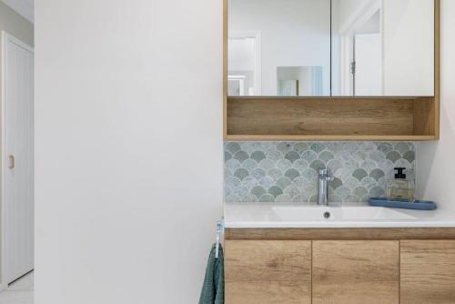 a bathroom with a sink and a mirror at The Salty Anchor in Banksia Beach