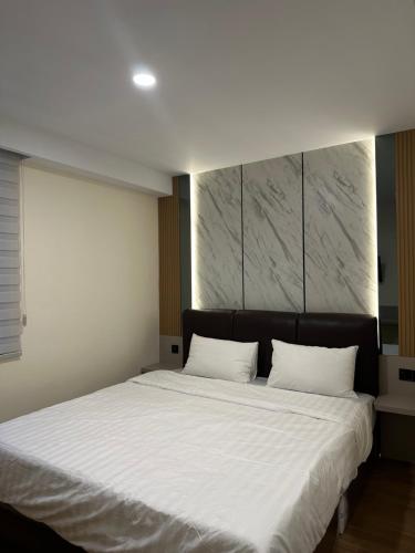 a bedroom with a large bed with white sheets at Serenity Homestay Penuin Batam in Batam Center