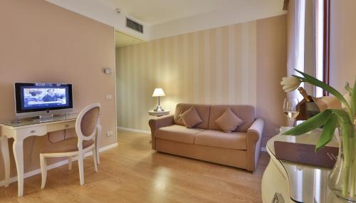 a living room with a couch and a table with a television at Bonotto Hotel Belvedere in Bassano del Grappa