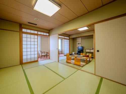 an empty room with a living room with a television at Hotel Luna Park in Matsuyama