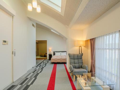 a living room with a bed and a red carpet at Hotel Luna Park in Matsuyama