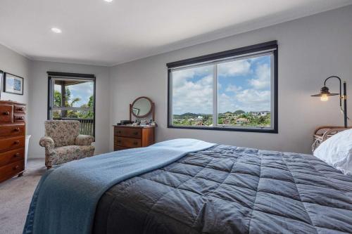 a bedroom with a bed and a large window at Cable Bay Serenity in Cable Bay