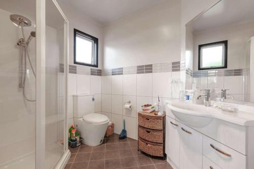 a bathroom with a toilet and a sink and a shower at Cable Bay Serenity in Cable Bay