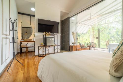 a bedroom with a bed and a large window at Örök Landscape Hotel in Rionegro