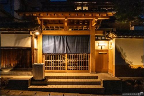 a building with a gate with a curtain on it at 春日光 HaruNikko Guesthouse - Traditional Japanese Guesthouse with Japanese Garden in Nikko