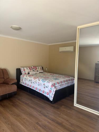 a bedroom with a bed and a mirror at Shaun place in Old Reynella