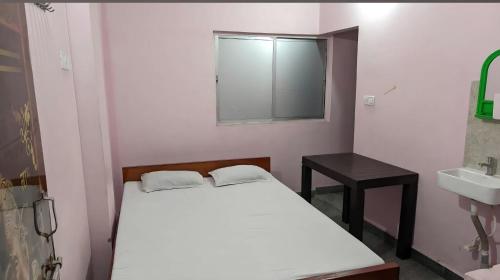 a bedroom with a bed and a sink and a mirror at Sri Hotel Ganga Couple&Family Friendly in Patna