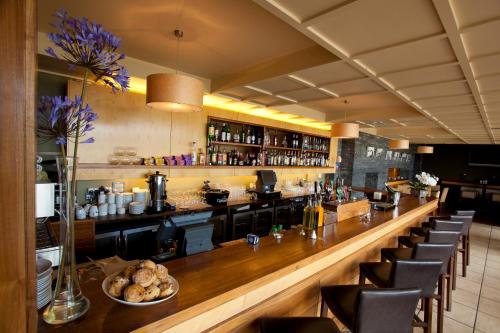 a bar in a restaurant with a long counter at Inishbofin House Hotel in Inishbofin