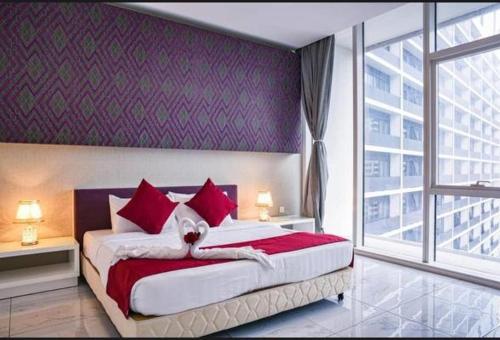 a bedroom with a large bed with red pillows at Platinum Face suits in Kuala Lumpur