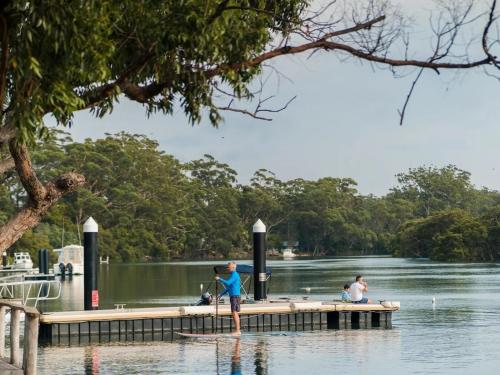 a man standing on a dock in the water at Tasman Holiday Parks - Jervis Bay in Huskisson
