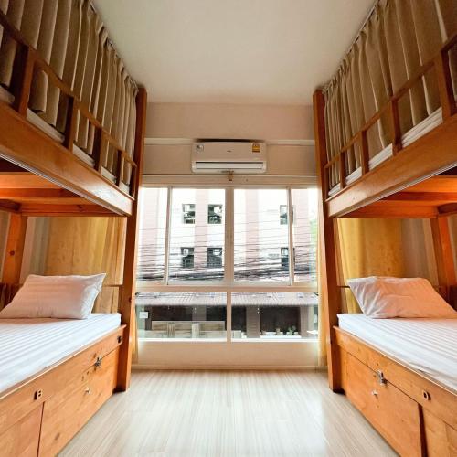 two bunk beds in a room with a window at Bunk Boutique in Chiang Mai