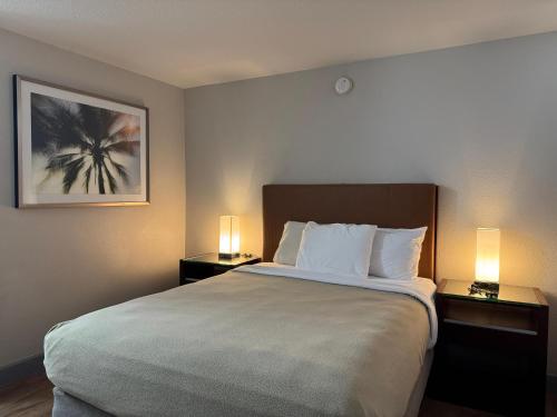 a hotel room with a large bed with two lamps at Harmony Inn and Suites in Beaumont