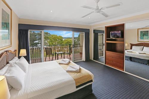 a hotel room with a bed and a balcony at Tinaroo Lake Resort in Tinaroo