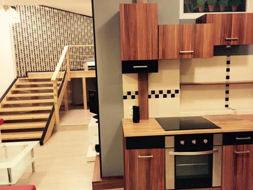 a kitchen with wooden cabinets and a staircase at Old Town Boutique Apartments in Liberec