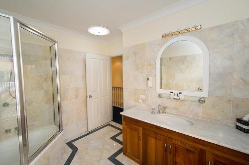 a bathroom with a sink and a shower and a mirror at Tinaroo Lake Resort in Tinaroo