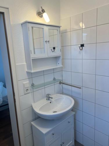 a white bathroom with a sink and a mirror at Hugo zwei in Warburg