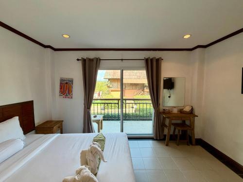 a bedroom with a bed and a view of a balcony at Paihappyvillage in Pai