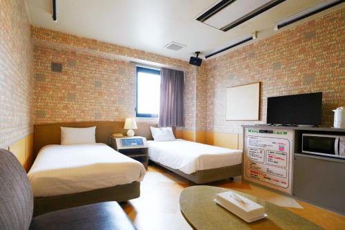 a hotel room with two beds and a tv at ホテル韮崎インター in Nirasaki