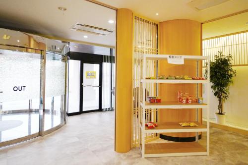 a room with a yellow wall and a shelf at ホテル韮崎インター in Nirasaki
