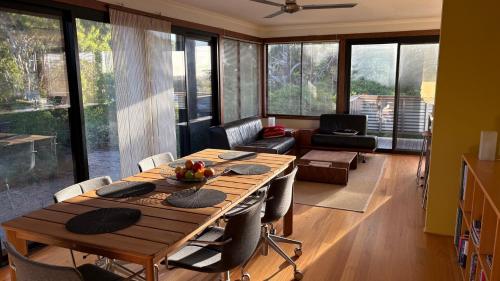 a dining room with a table and a living room at On The Hill at Metung - Quiet Retreat with Views in Metung