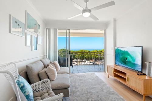 a living room with a couch and a tv at Alex Beach Front Nest in Alexandra Headland
