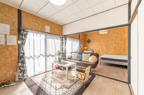 a living room with a couch and a table at Jupiter 糸島市1棟貸し切り宿 in Itoshima