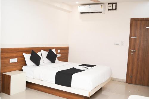 a bedroom with a white bed with a wooden headboard at Stay Prime, Balewadi in Pune