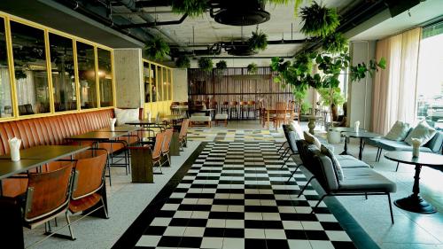 a restaurant with tables and chairs and a checkered floor at Marina House MUAYTHAI Ta-iad Phuket in Chalong
