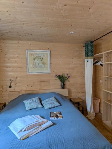 デュールフィにあるL’escaleの木造の部屋に青いベッドが置かれた寝室