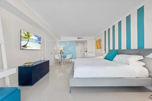 a bedroom with a large bed and a dining room at Arya Hotel & Suites in Miami