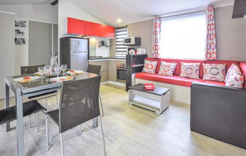 a kitchen and living room with a red couch at Mobile-Home Proche Mer 400M in Grandcamp-Maisy