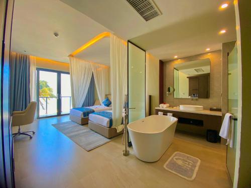 a bathroom with a tub and a bedroom with a bed at Matemwe Sands Beach Resort in Mkuyuni Pwani